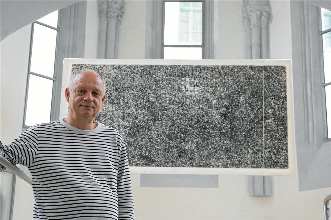 Philipp Hennevogl zeigt in Backnang vorwiegend Linolschnitte. Bei dem großformatigen Werk im Chor mit dem Titel „Paralleluniversum“ handelt es sich hingegen um einen Materialdruck – der Künstler hat den Fußboden einer Kneipe abgedruckt. Foto: Alexander Becher