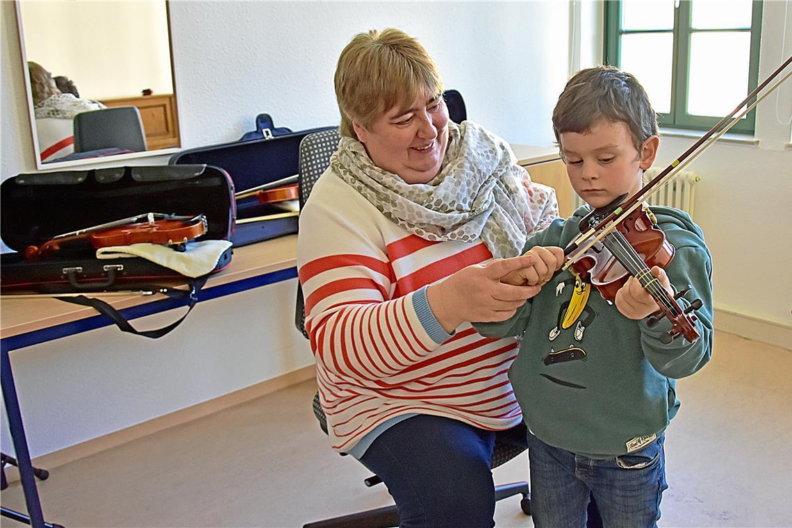 Die Suche nach dem passenden Instrument Philo versucht sich an der Violine unter der Anleitung von Wiltrud Hümmelchen. Foto: Tobias Sellmaier