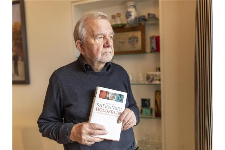 Philosoph Rüdiger Safranski steht in seinem Haus und hält sein Buch "Hölderlin" in den Händen. Foto: Patrick Seeger/dpa