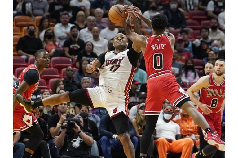P.J. Tucker (M, l) von Miami Heat und Coby White von Chicago Bulls kämpfen in der ersten Halbzeit um dem Ball. Foto: Marta Lavandier/AP/dpa