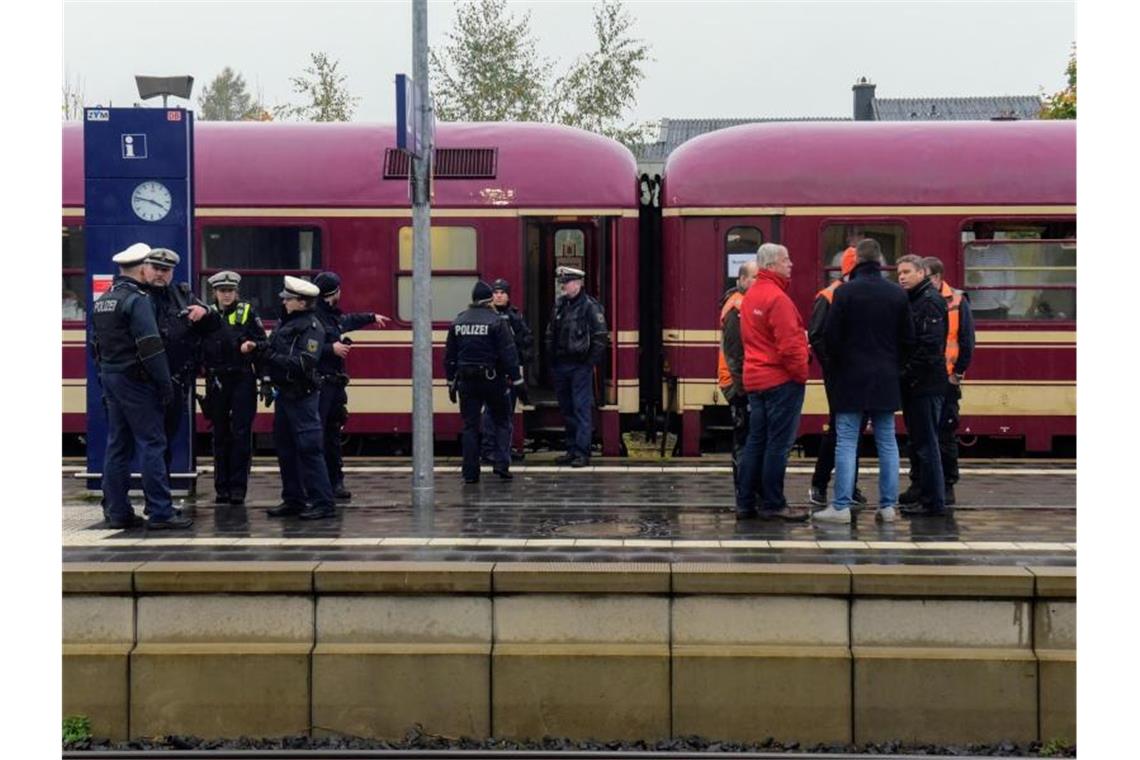 Poizisten und Reisende stehen am Freitag neben dem Partyzug, nachdem er in Greven gestoppt wurde. Foto: Günter Benning/dpa