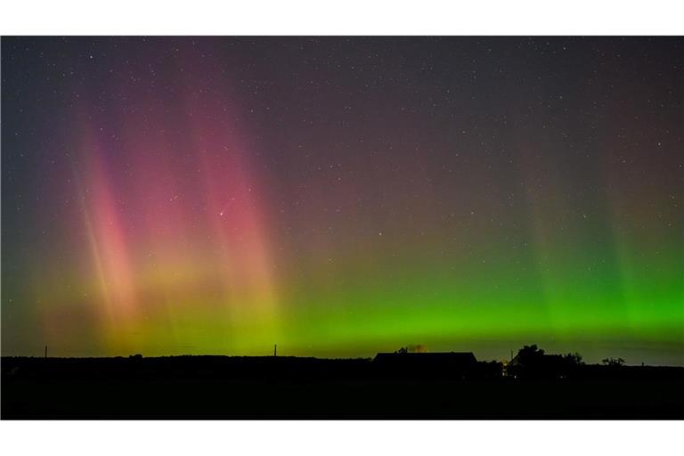 Polarlicht und Komet leuchten am Nachthimmel.