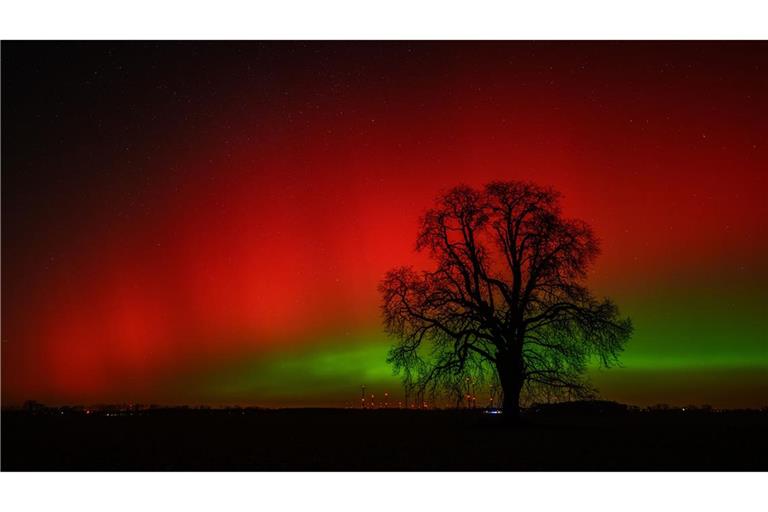 Polarlichter leuchten am Nachthimmel über der Landschaft im östlichen Brandenburg. Dieses Nordlicht (Aurora borealis) wurde durch eine Wolke elektrisch geladener Teilchen eines Sonnensturms in der Erdatmosphäre erzeugt.