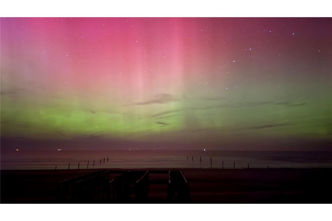 Polarlichter leuchten am Nachthimmel über der Nordsee.