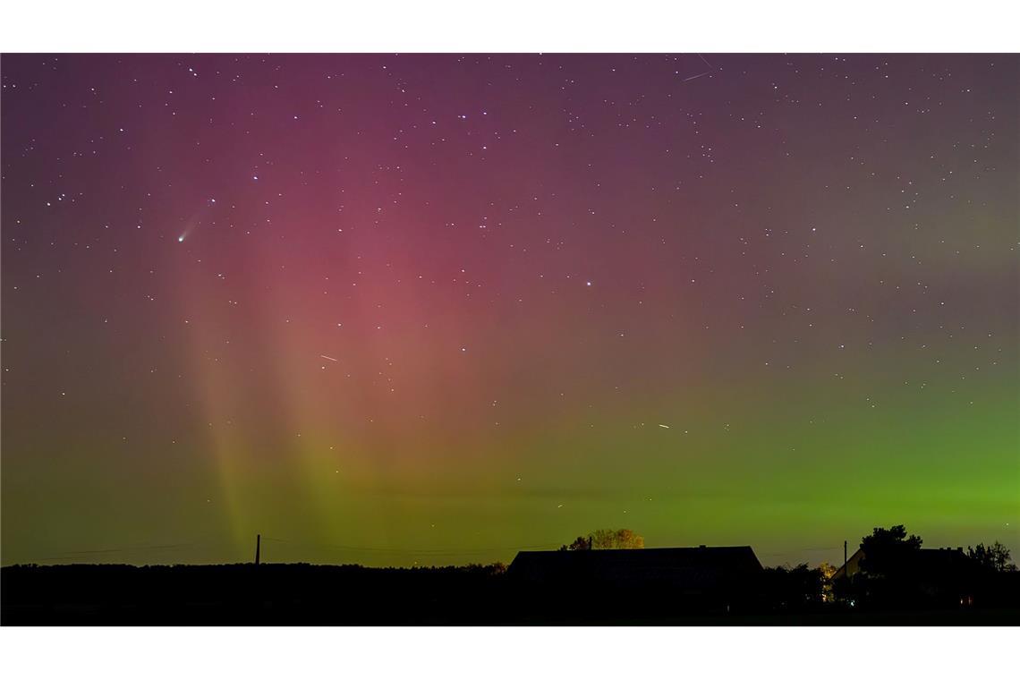 Bilder des Tages Polarlichter und der Komet Lemmon "C/2025 A6" (Bildmitte links) leuchten am Nachthimmel über der Landschaft im östlichen Brandenburg.