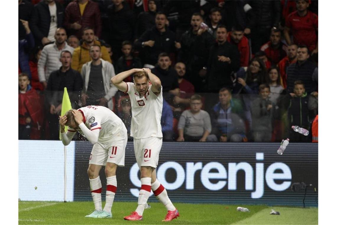 FIFA ermittelt nach Ausschreitungen in Wembley und Albanien Polen Spieler schützen sich vor den Flaschenwürfen der albanischen Anhänger. Foto: Franc Zhurda/AP/dpa