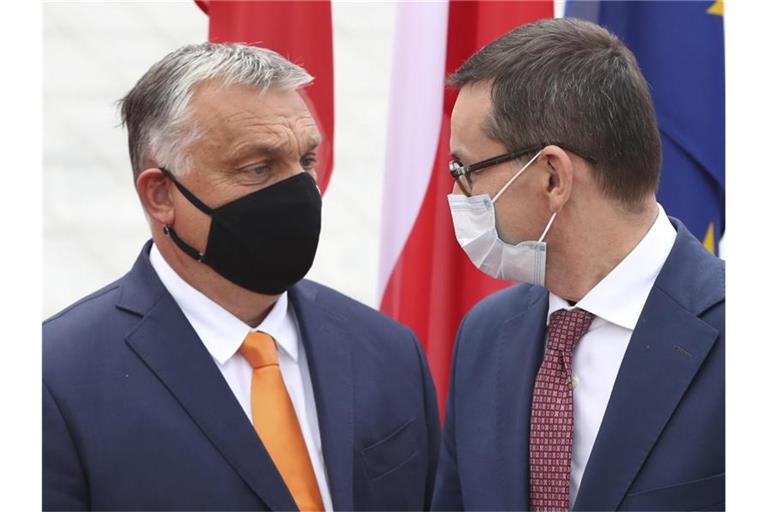 Polens Premierminister Mateusz Morawiecki begrüßt seinen ungarischen Amtskollegen Viktor Orban. Eine Mehrheit der EU-Staaten hat ungeachtet von Drohungen aus Ungarn und Polen ein Verfahren zur Bestrafung von Verstößen gegen die Rechtsstaatlichkeit innerhalb der Union auf den Weg gebracht. Foto: Czarek Sokolowski/AP/dpa