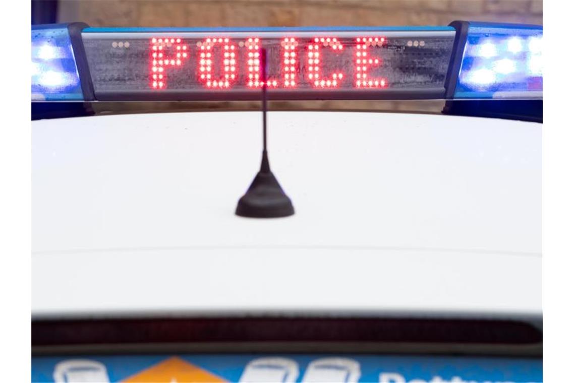 "Police" steht auf dem Display eines Polizeiwagens mit angeschaltetem Blaulicht. Foto: Friso Gentsch/dpa/Archivbild