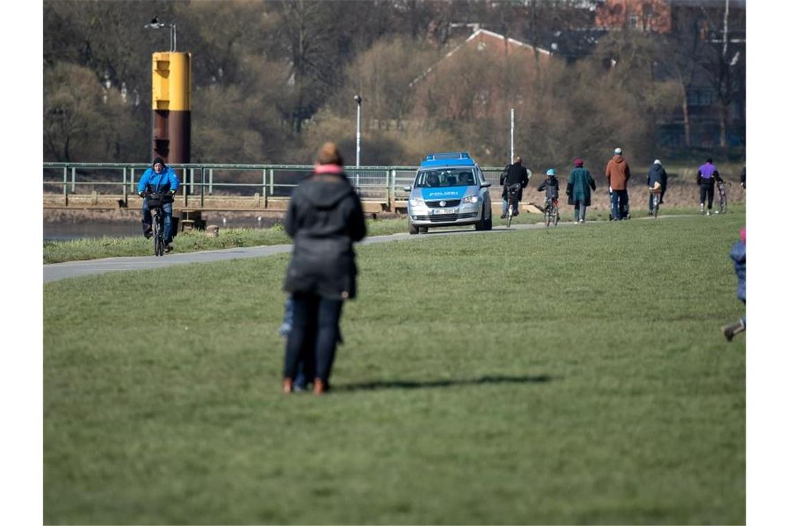 Polizei fährt den Osterdeich in Bremen entlang, um das Kontaktverbot zu kontrollieren. Foto: Sina Schuldt/dpa