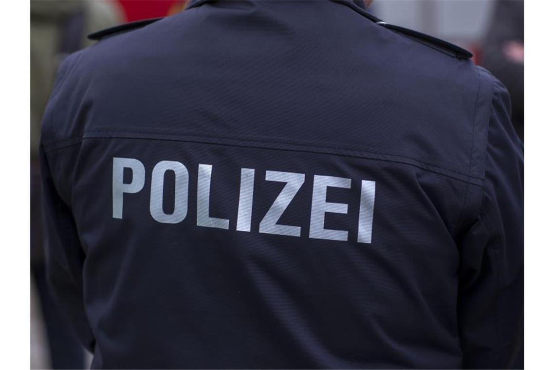 „Polizei“ steht auf der Uniform eines Polizisten. Foto: Jens Büttner/zb/dpa/Symbolbild