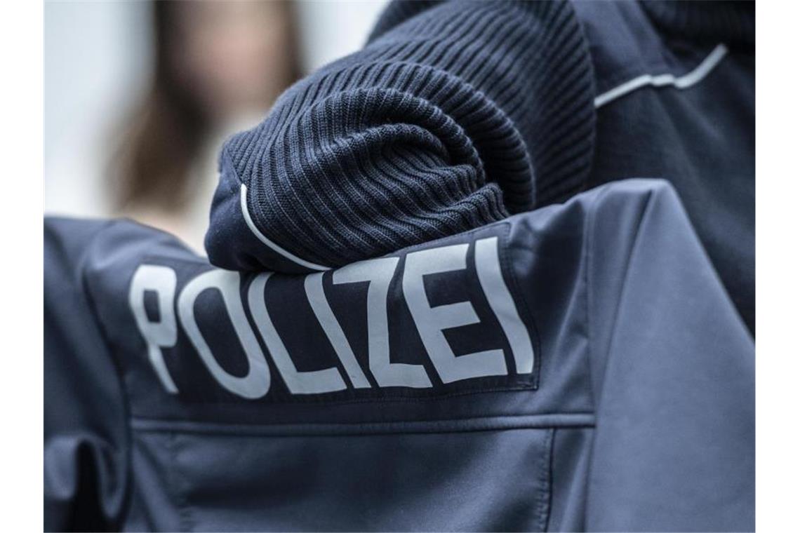 Polizei kontrolliert Verstöße: Tausende in den Straßen "Polizei" steht auf einer Uniform. Foto: Paul Zinken/dpa