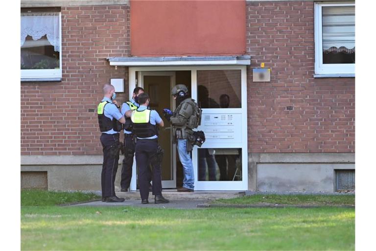 Polizei und ein SEK-Beamte während ihres Einsatzes vor einem Mehrfamilienhauses in Krefeld. Foto: Alexander Forstreuter/-/dpa