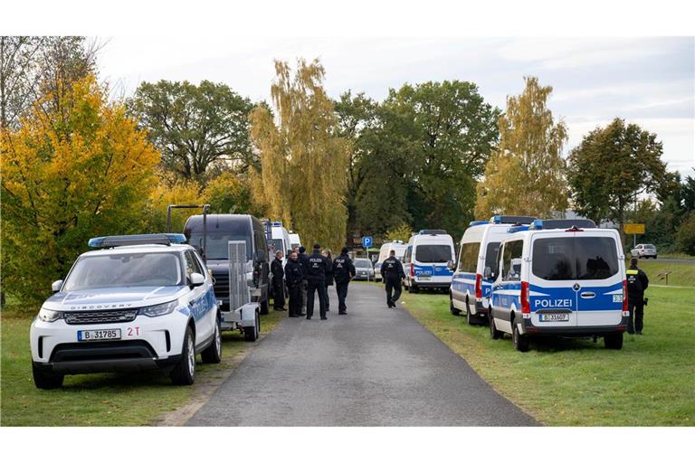 Polizeiautos stehen auf einer Wiese in Tauche.