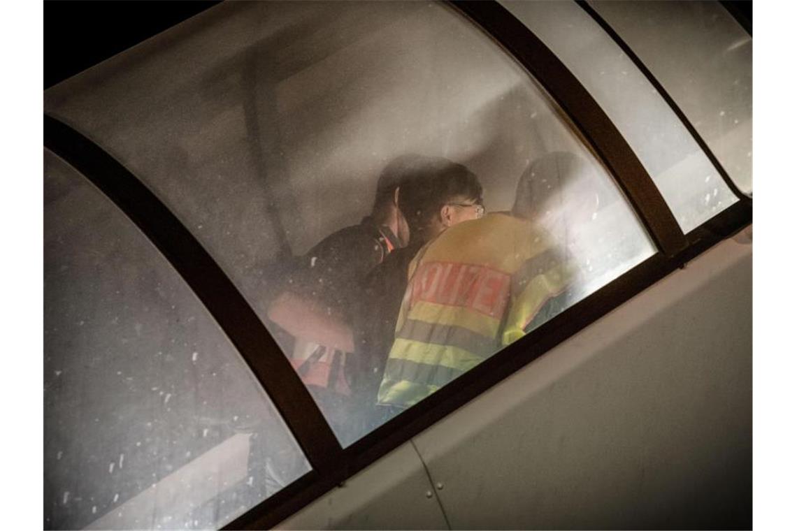 Abschiebestopp für Syrer wird vorerst nicht eingeschränkt Polizeibeamte begleiten einen abgewiesenen Asylbewerber zum Flugzeug. Foto: Michael Kappeler/dpa/Archivbild