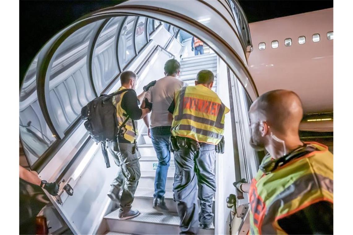 Tausende Asylbewerber wurden schon mehrmals abgeschoben Polizeibeamte begleiten einen Afghanenn in ein Flugzeug. Foto: Michael Kappeler/dpa