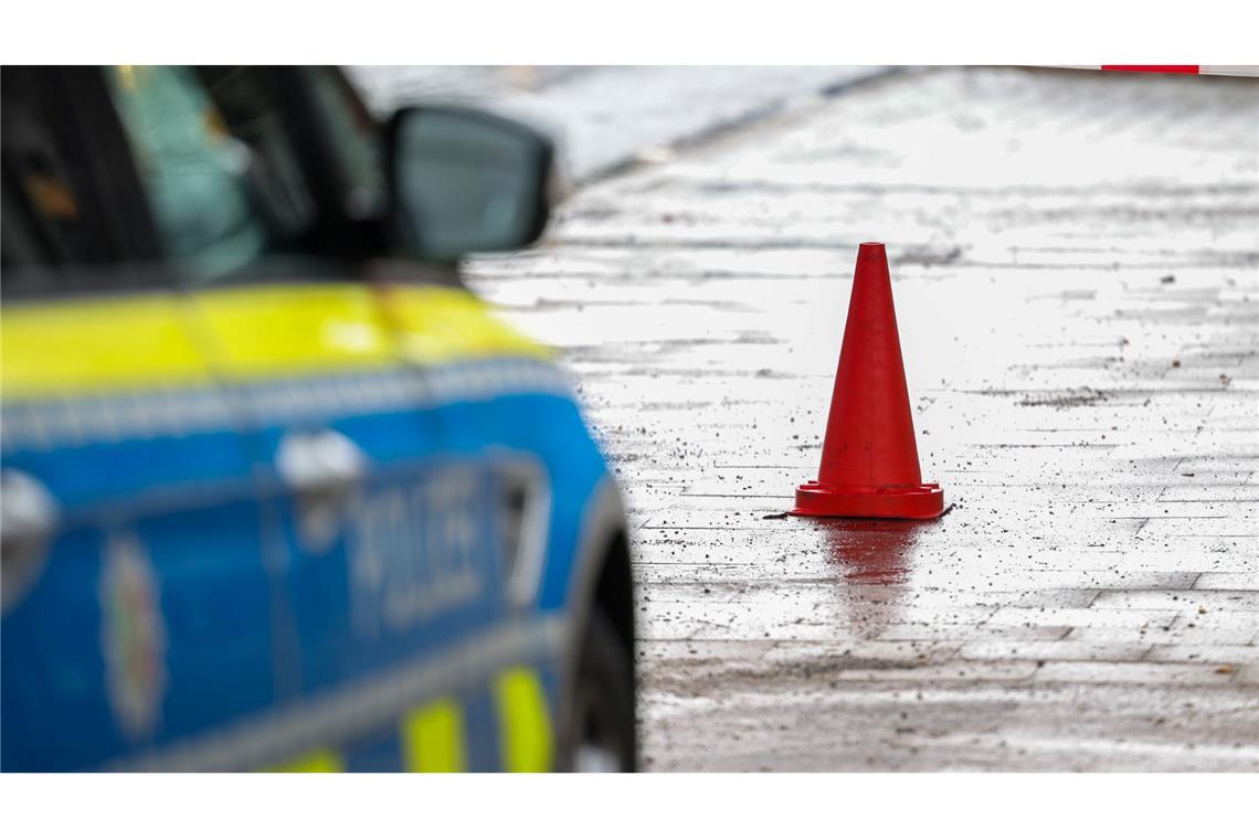 Polizeibeamte bewachen in einem Streifenwagen den Tatort.
