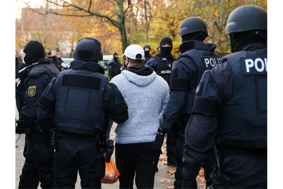 Polizeibeamte bringen bei einem Einsatz in der Gitschiner Straße eine Person zur Identitätsprüfung. Foto: Annette Riedl/dpa