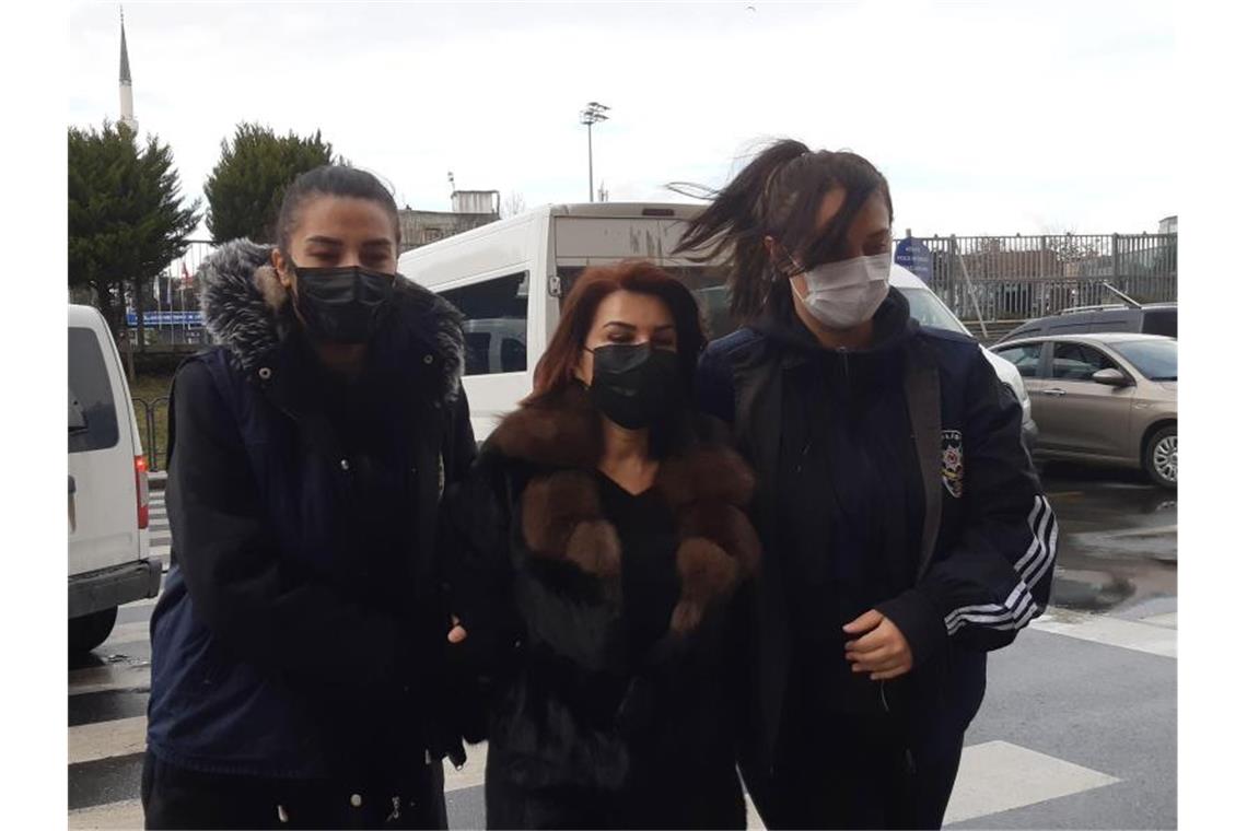 Polizeibeamte eskortieren Sedef Kabas, eine bekannte türkische Journalistin, vor ihrem Auftritt vor Gericht in Istanbul. Foto: IHA/dpa