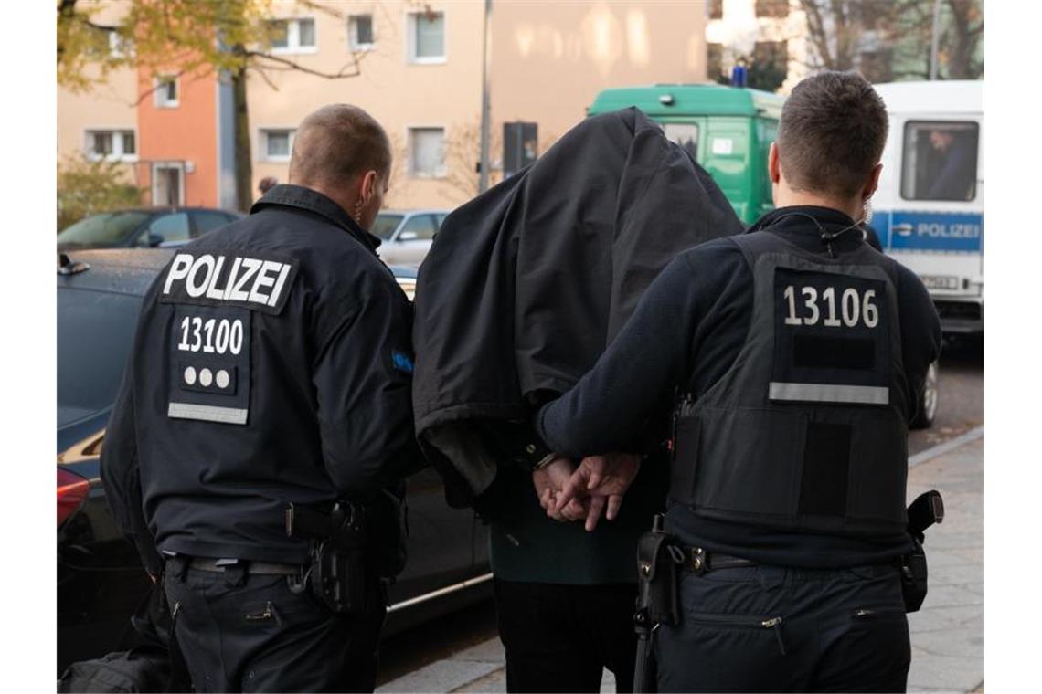 Polizeibeamte führen einen Mann nach einer Razzia in Berlin ab. Der Einsatz richtete sich gegen kriminelle Clan-Mitglieder. Foto: Paul Zinken/dpa/Archiv