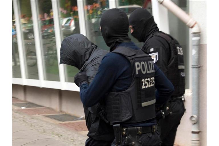 Polizeibeamte führen im Juli in Berlin einen Mann ab. Foto: Paul Zinken