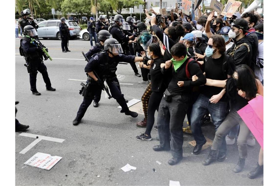 Polizeibeamte in Los Angeles versuchen, Demonstranten während eines Protestes auf einer Straße zurückzudrängen. Foto: -/XinHua/dpa