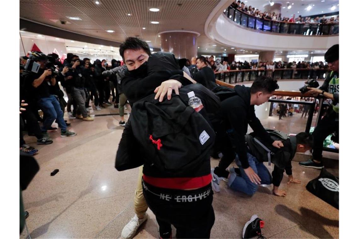 Chaos und Zusammenstöße überschatten Weihnachten in Hongkong Polizeibeamte in Zivil geraten in einem Einkaufszentrum mit Demonstranten aneinander. Foto: Lee Jin-Man/AP/dpa