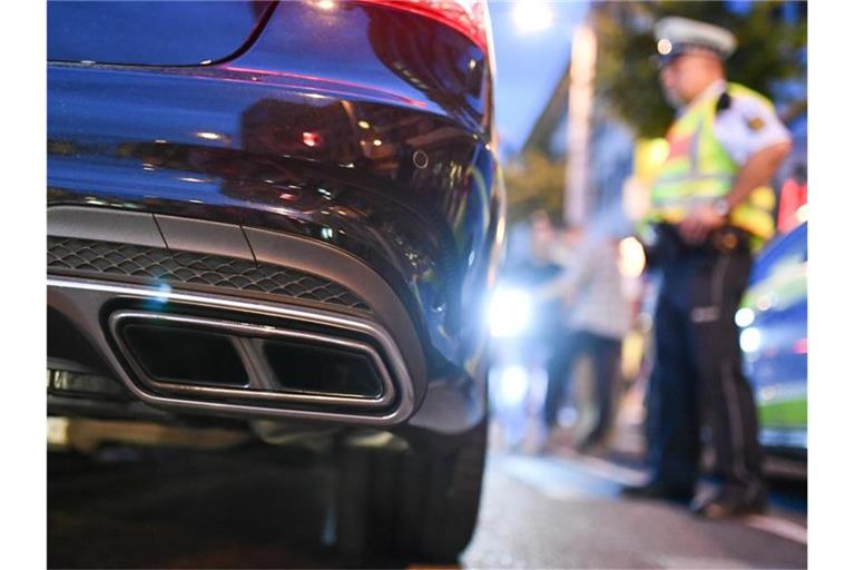 Polizeibeamte kontrollieren sogenannte Autoposer. Foto: Uwe Anspach/dpa/Archivbild
