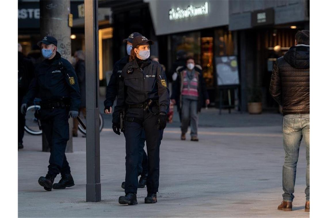 Fast 50 000 Verstöße gegen Corona-Regeln im November Polizeibeamte mit Maske gehen durch die Innenstadt von Stuttgart. Foto: Sebastian Gollnow/dpa