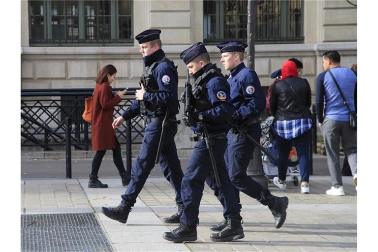 Polizeibeamte patrouillieren mit Gewehren vor dem Pariser Polizeipräsidium. Foto: Michel Euler/AP/dpa