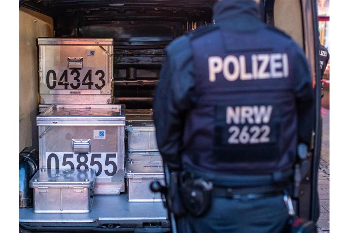 Polizeibeamte sichern kistenweise Beweise nach einer Durchsuchung in einem Geschäft. Foto: Christoph Reichwein/dpa
