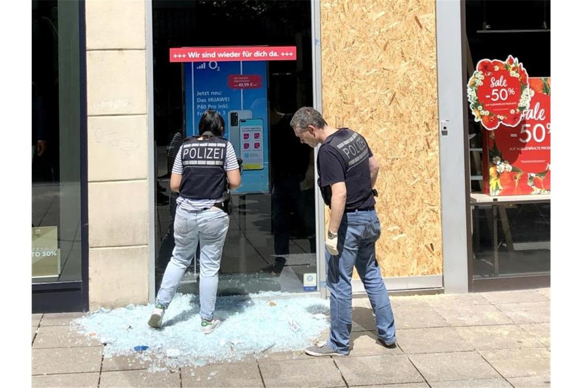 Polizeibeamte sichern Spuren vor einem beschädigten Geschäft in der Stuttgarter Innenstadt. Foto: Felix Schröder/dpa