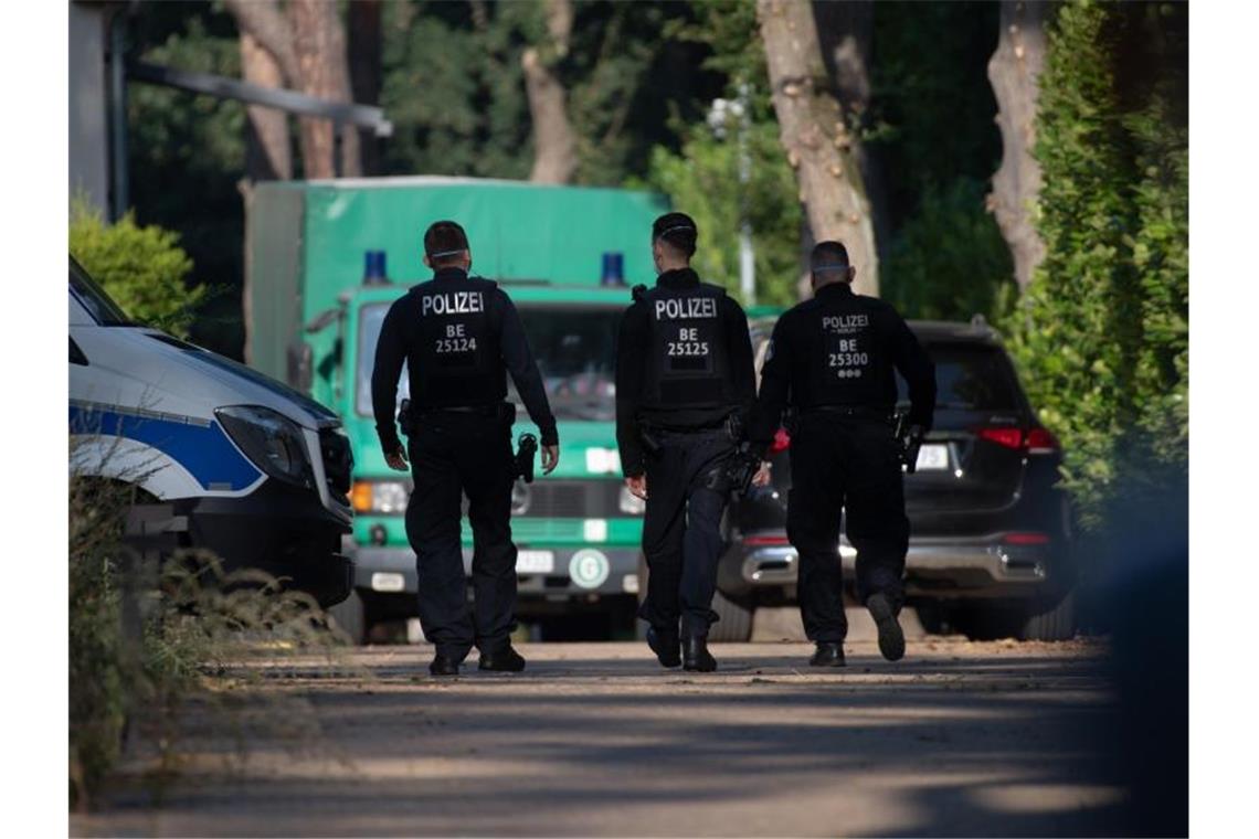 Polizeibeamte sind im Rahmen einer Durchsuchung auf einem Grundstück in Brandenburg unterwegs. Foto: Paul Zinken/dpa-Zentralbild/dpa