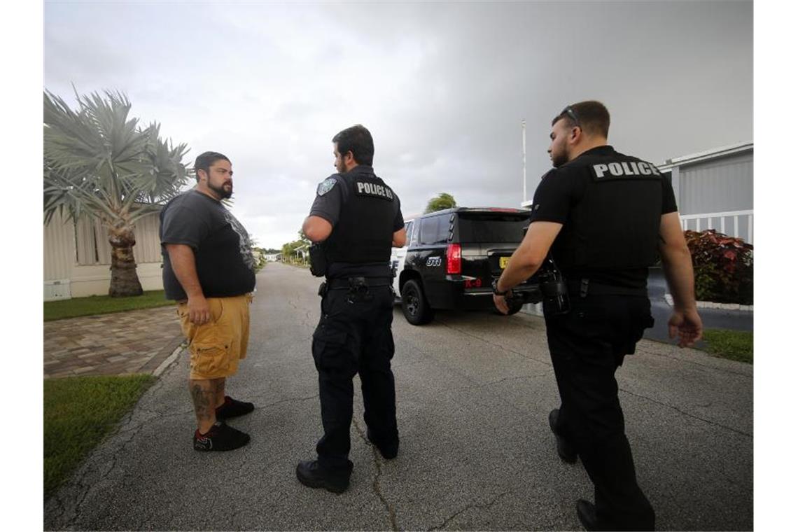 Polizeibeamte sprechen mit einem Anwohner in Florida über die bevorstehende Evakuierung. Foto: Gerald Herbert/AP