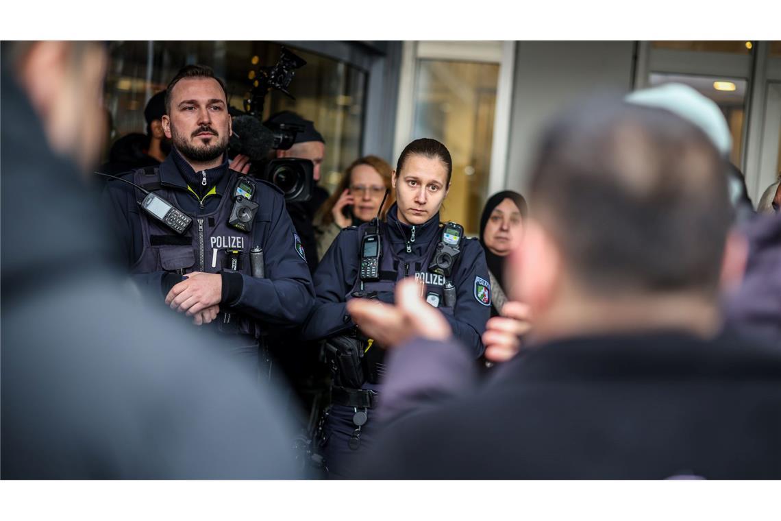 Polizeibeamte sprechen mit möglicherweise betroffenen Kunden der Sparkassenfiliale in Buer.