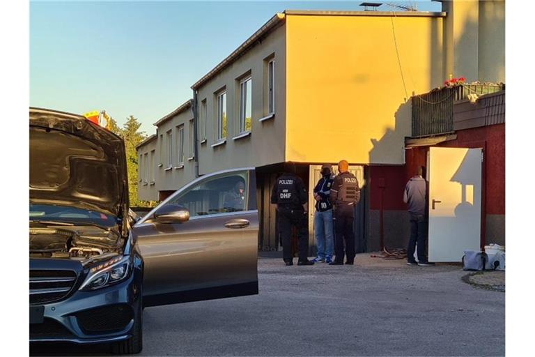 Polizeibeamte stehen auf einem Anwesen. Bei einer Razzia gegen Clankriminalität sind in Nordrhein-Westfalen am frühen Morgen mehrere Wohnungen und Firmen durchsucht worden. Foto: Gianni Gattus/dpa