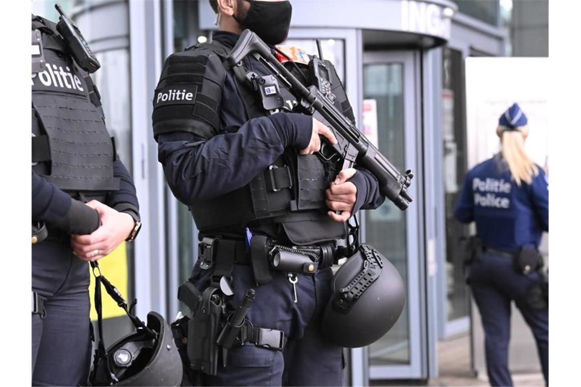 Polizeibeamte stehen bewaffnet vor Prozessbeginn vor dem Eingang des Gerichts. Foto: Dirk Waem/BELGA/dpa