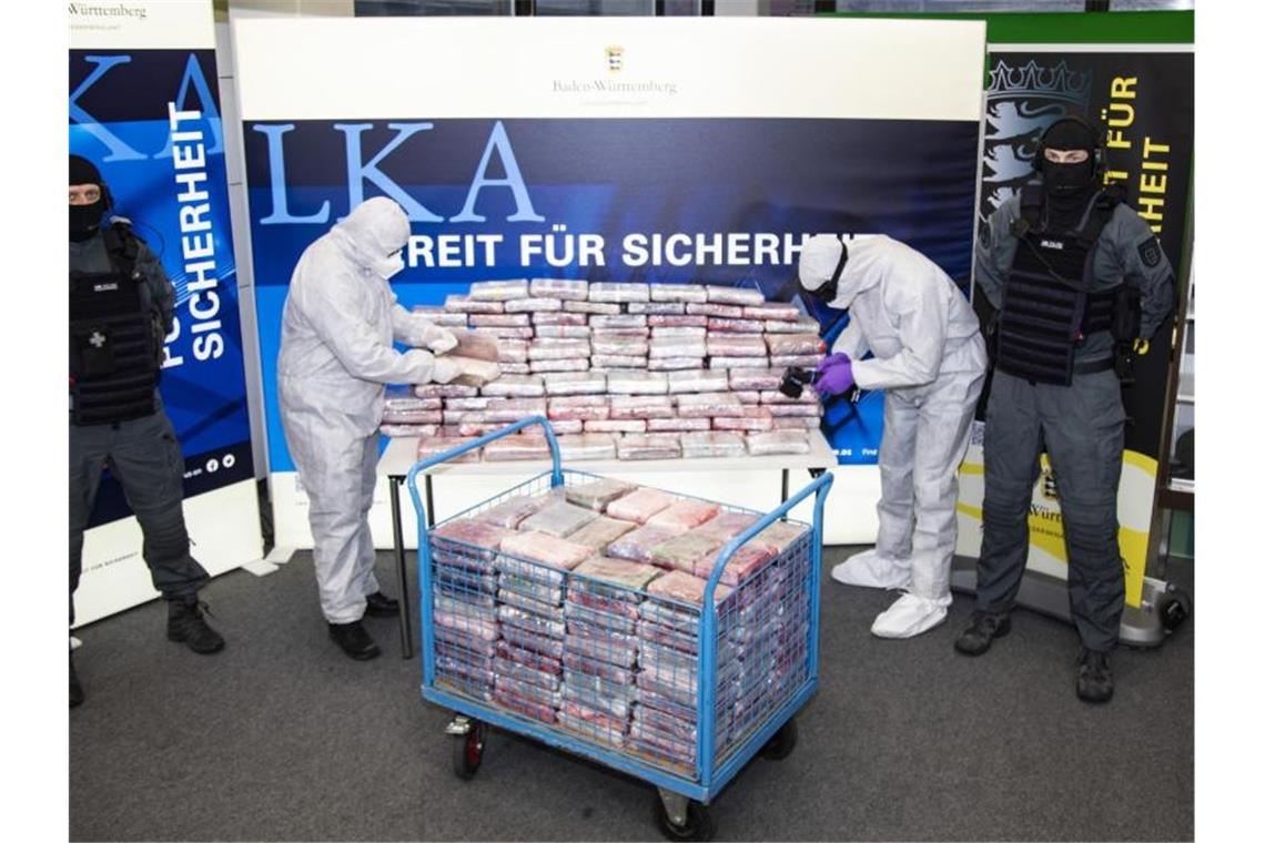 Kokain im Wert von 20 Millionen Euro zwischen Obst gelagert Polizeibeamte stehen neben einem Berg an Kokain-Paketen. Foto: dpa/Archivbild