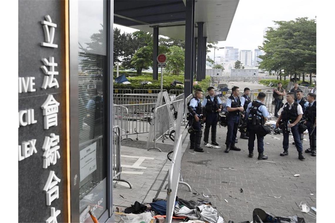 Polizeibeamte stehen vor dem Legislativrat Wache. In der Nacht zuvor war es zu gewaltsamen Zusammenstößen mit Demonstranten gekommen. Foto: Kyodo