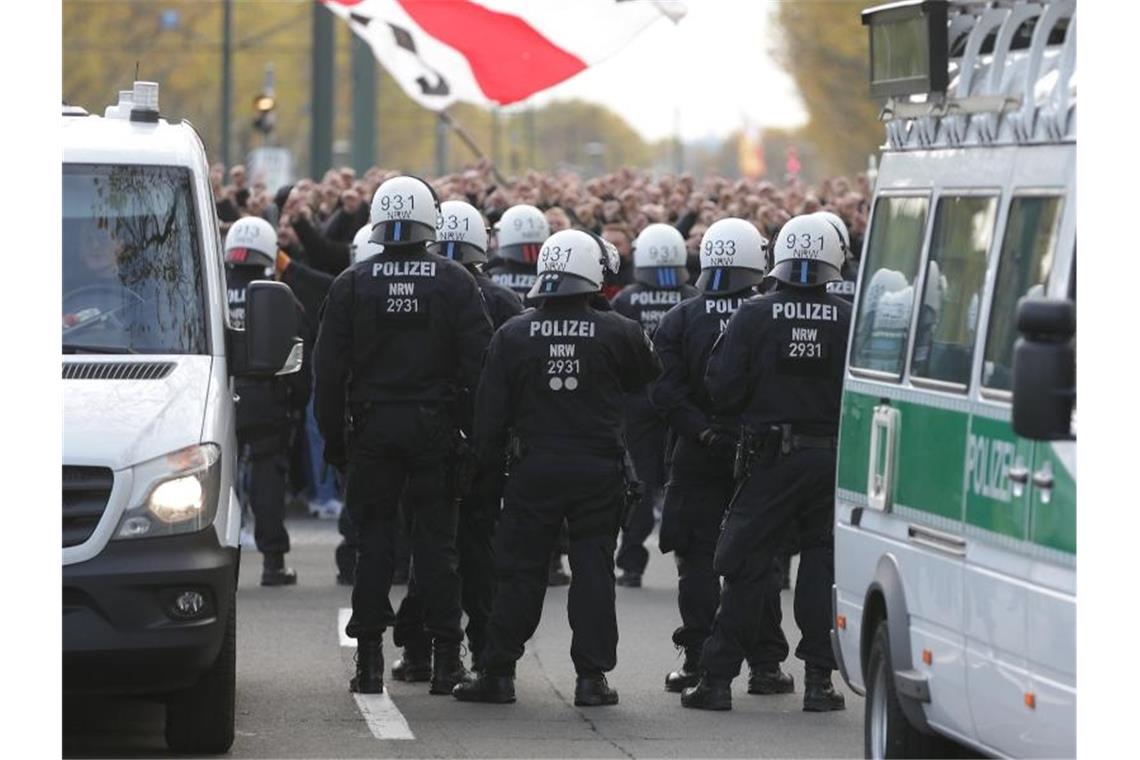 Polizeibeamte stehen vor den Fans von Fortuna Düsseldorf in Stadionnähe vor Spielbeginn. Foto: David Young/dpa