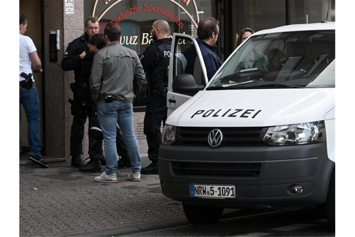 Polizeibeamte stehen vor einem Haus in der Josef-Schregel-Straße in Düren, das wegen Terrorverdachts durchsucht wird. Foto: Henning Kaiser