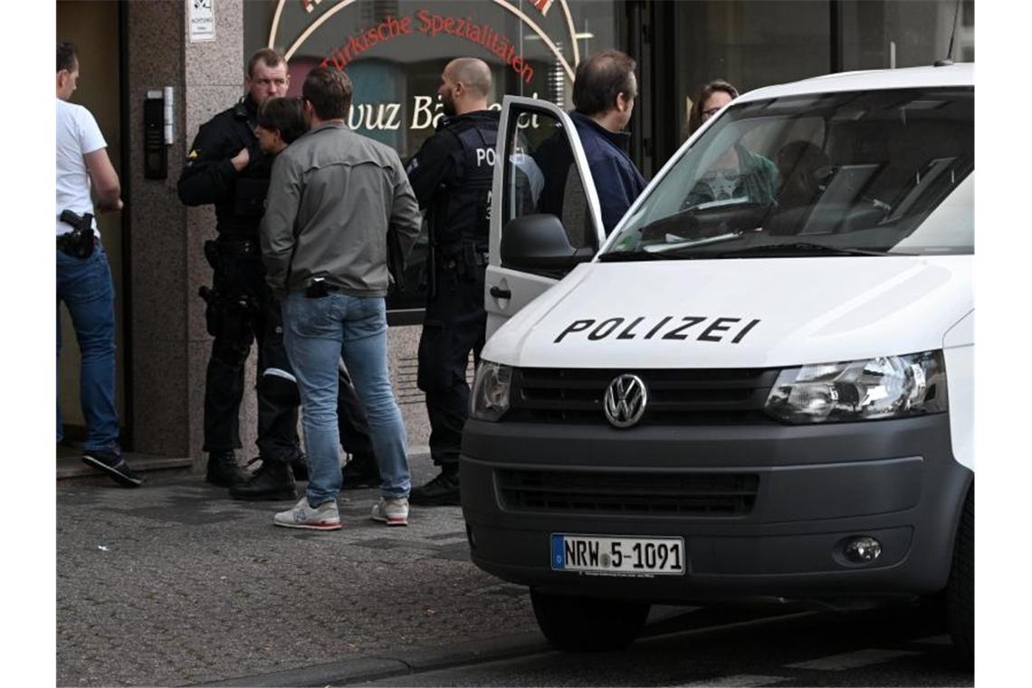 Razzia gegen Islamisten - kein konkreter Anschlagsplan Polizeibeamte stehen vor einem Haus in der Josef-Schregel-Straße in Düren, das wegen Terrorverdachts durchsucht wird. Foto: Henning Kaiser