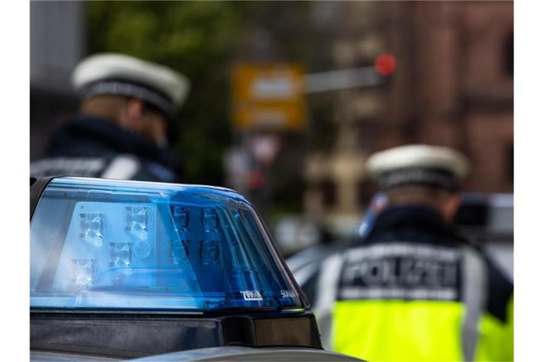 Polizeibeamte stehen zwischen Einsatzfahrzeugen der Polizei. Foto: Philipp von Ditfurth/dpa/Symbolbild