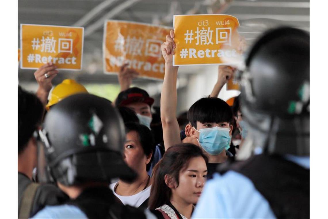 EU stellt sich hinter Demonstranten in Hongkong Polizeibeamte umzingeln Demonstranten: Die Situation in Hongkong bleibt angespannt. Foto: Kin Cheung/AP