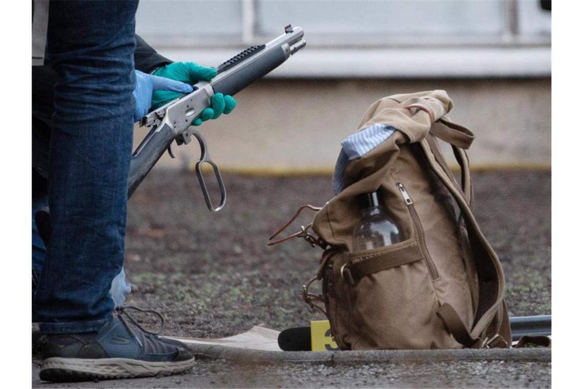 Polizeibeamte untersuchen eine Waffe am Gelände der Heidelberger Universität. Foto: Sebastian Gollnow/dpa