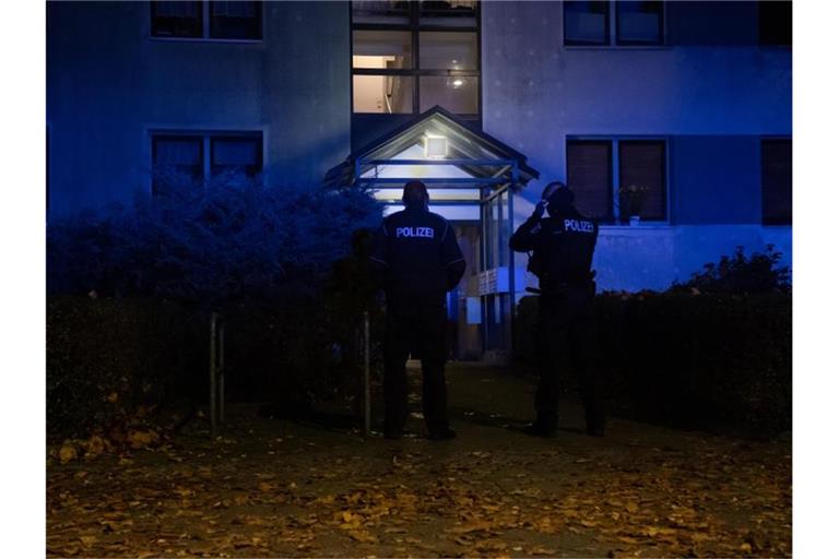 Polizeibeamte vor einem Mehrfamilienhaus im Berliner Ortsteil Plänterwald. Foto: Paul Zinken/dpa