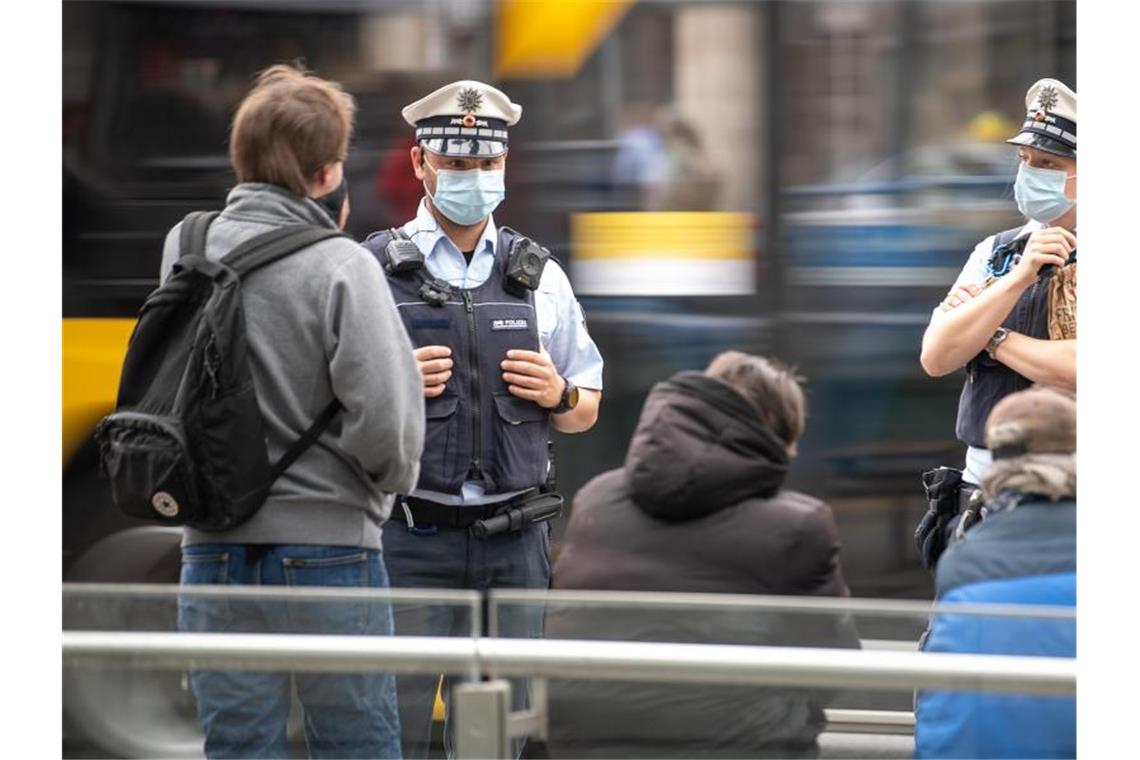 Polizeibeamte weisen auf die Einhaltung der Corona-Ordnung hin. Foto: Sebastian Gollnow/dpa/Archivbild