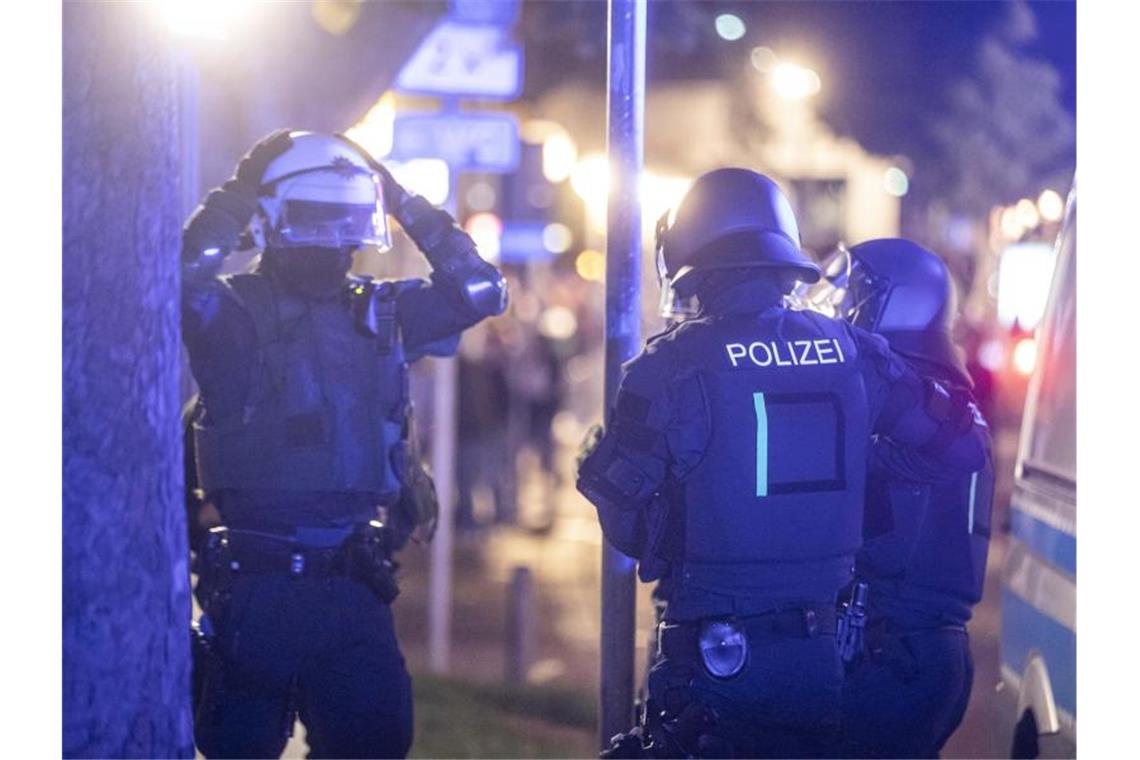 Polizeieinheiten sammeln sich, um gegen die Randalierer vorzugehen. Foto: Simon Adomat/dpa