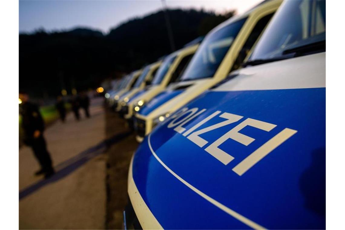 Polizeifahrzeuge an einem Sportplatz nahe Oppenau, der der Polizei als Sammelpunkt diente. Foto: Philipp von Ditfurth/dpa