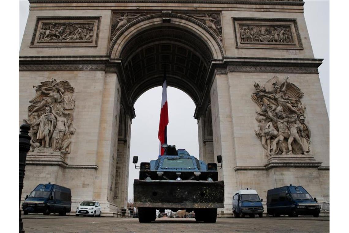 Polizeifahrzeuge parken am Arc de Triomphe in Paris. Foto: Francois Mori/AP/dpa