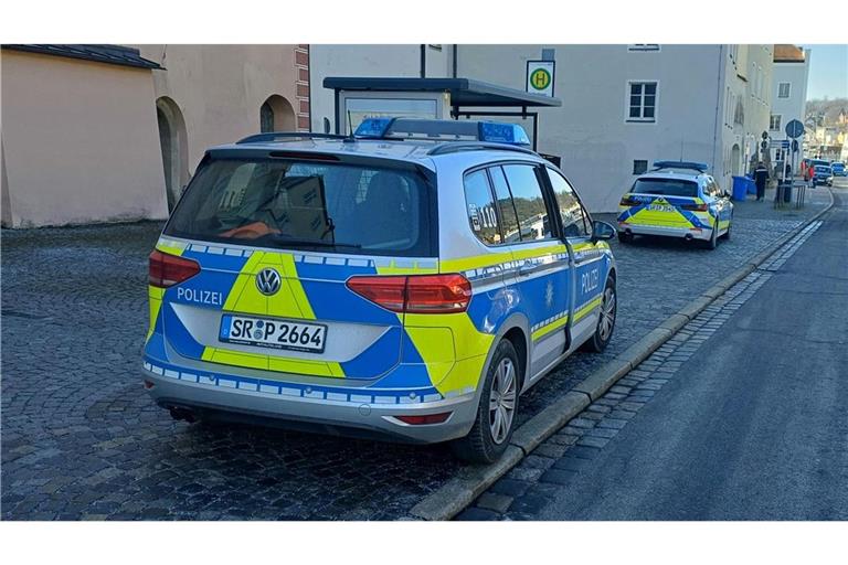 Polizeifahrzeuge stehen auf der Straße. Nach der Flucht eines Verdächtigen bei der Vorführung im Amtsgericht sucht die Polizei in Passau mit einem Großaufgebot nach dem Mann.